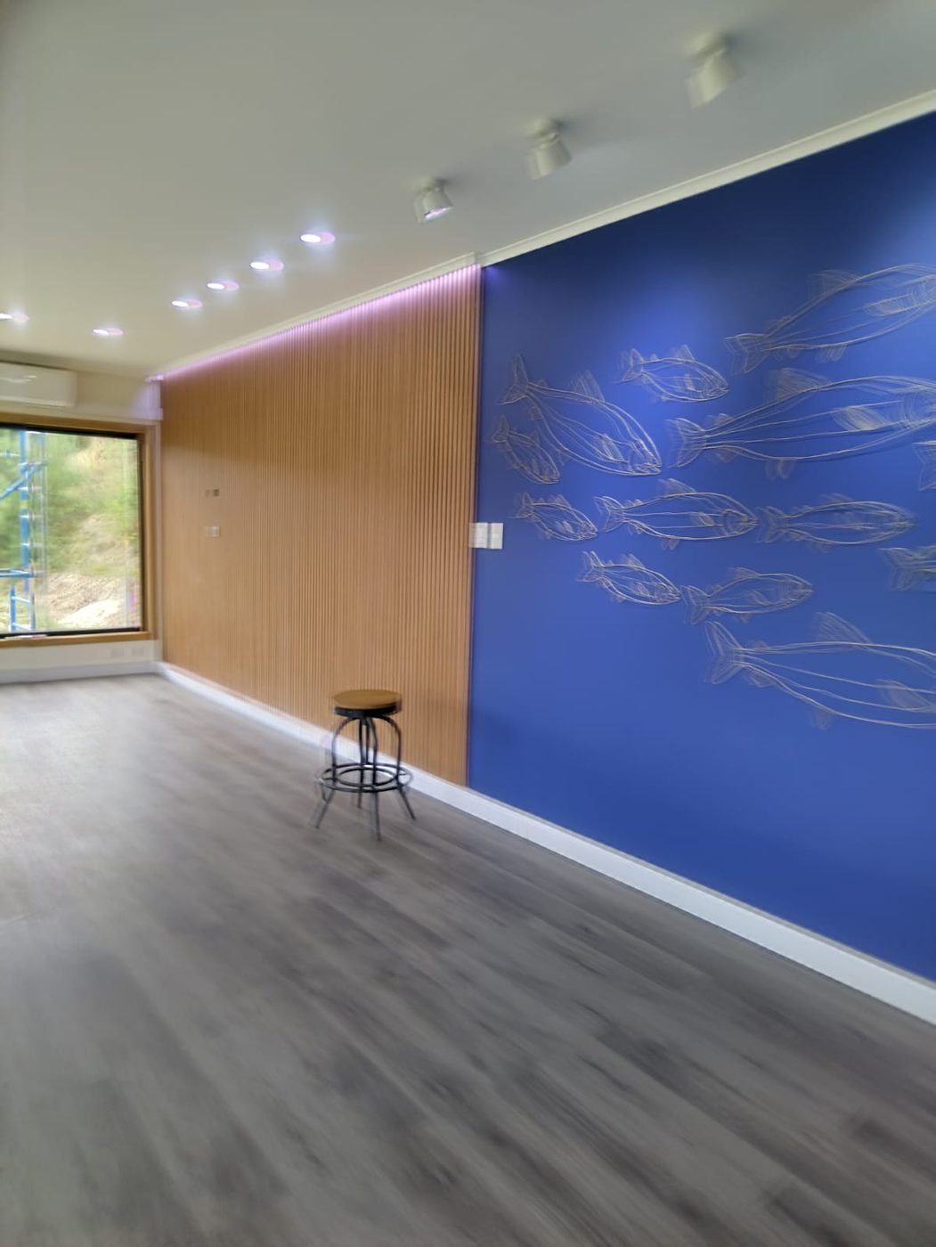 Interior terminado de la tienda La Isla Invermar, con mural de peces y revestimiento de madera